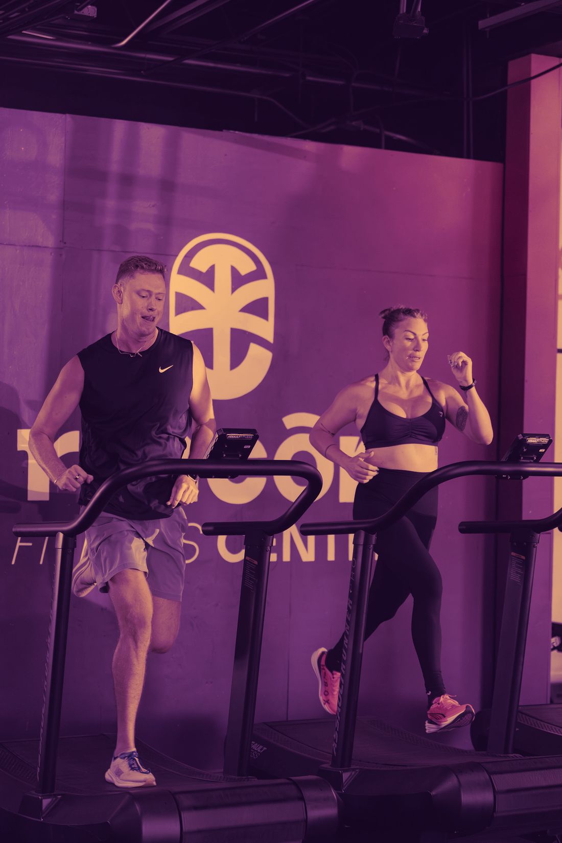 Two RFC athletes running side by side on treadmills during a HYROX simulator